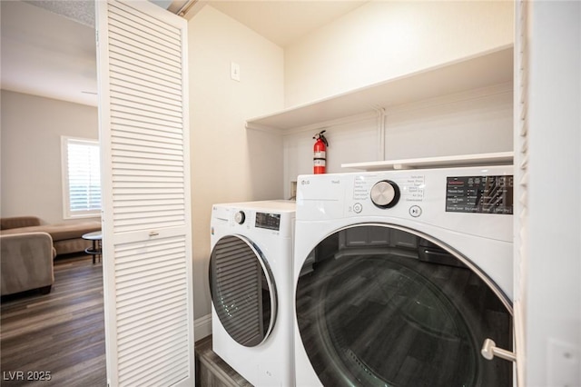 clothes washing area with laundry area, wood finished floors, and washing machine and clothes dryer