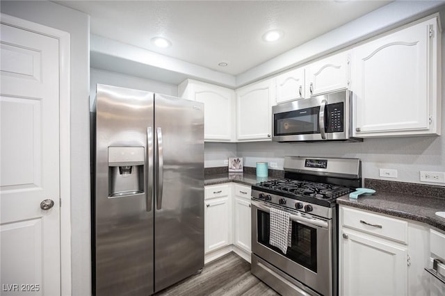 kitchen featuring white cabinetry, appliances with stainless steel finishes, dark wood-style floors, and dark countertops