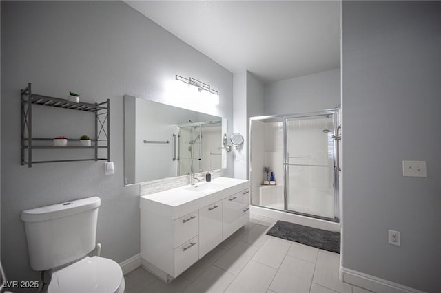 bathroom with vanity, toilet, baseboards, tile patterned floors, and a shower stall