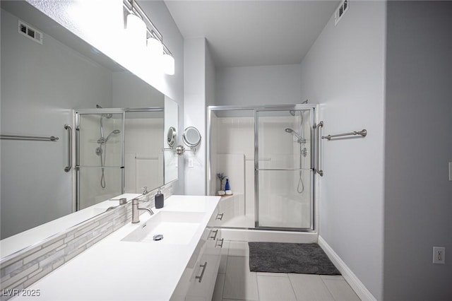 bathroom featuring vanity, a stall shower, and visible vents