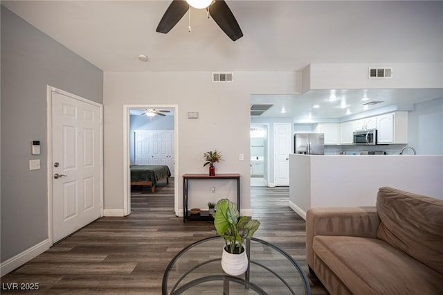 living area featuring a ceiling fan, dark wood-type flooring, and visible vents