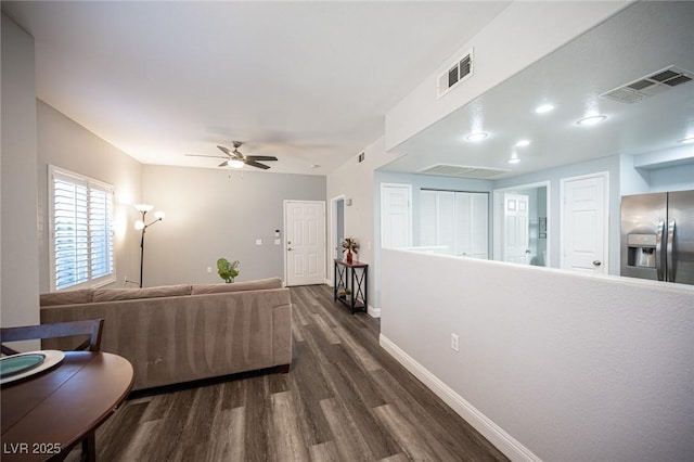 living area with a ceiling fan, baseboards, visible vents, and dark wood finished floors