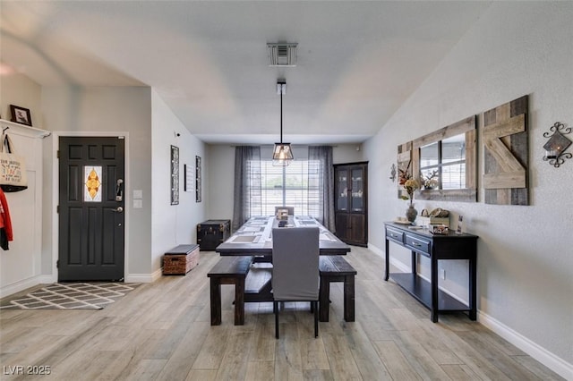 dining area featuring baseboards, light wood finished floors, and visible vents