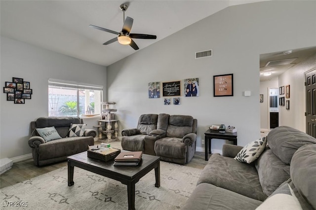 living area with visible vents, baseboards, ceiling fan, high vaulted ceiling, and light wood finished floors