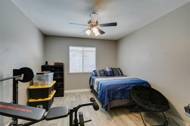 bedroom featuring baseboards, ceiling fan, and wood finished floors
