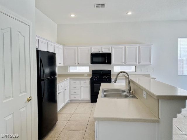 kitchen with a sink, light countertops, black appliances, and visible vents