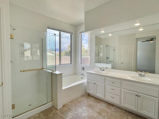 full bathroom with a sink, double vanity, a shower stall, and a garden tub