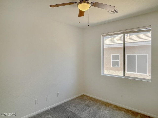 carpeted empty room with ceiling fan, visible vents, and baseboards
