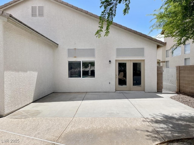 back of house featuring fence, stucco siding, and a patio area