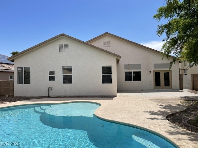 pool featuring fence, a patio area, and french doors