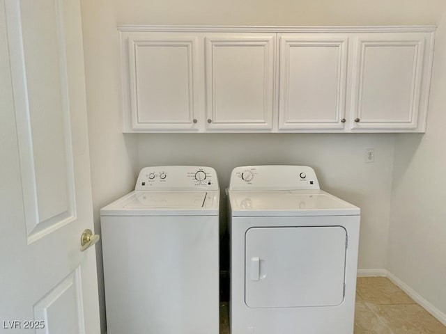 clothes washing area with baseboards, light tile patterned flooring, cabinet space, and washer and clothes dryer