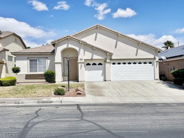 single story home featuring an attached garage, stucco siding, a tile roof, and concrete driveway