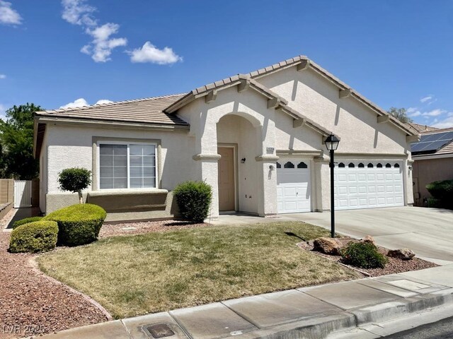 view of front of home featuring a garage, stucco siding, a tile roof, and concrete driveway