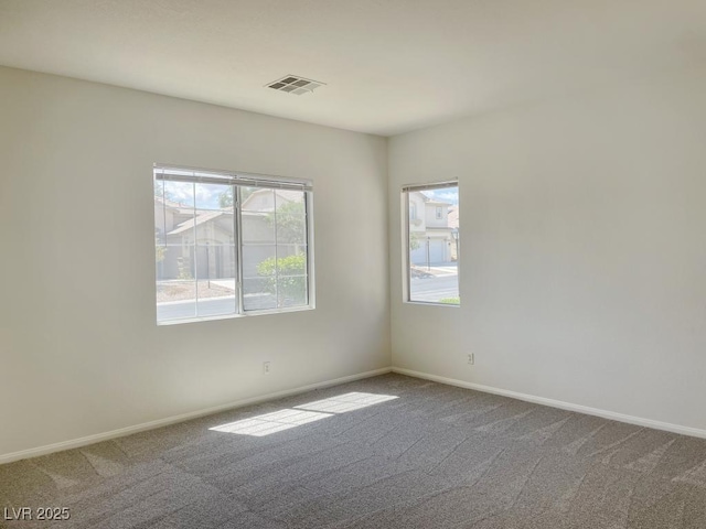 carpeted empty room featuring baseboards and visible vents