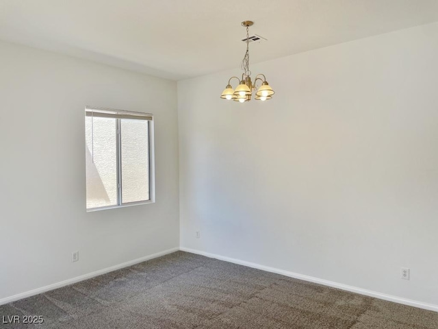 empty room with baseboards, a notable chandelier, and dark carpet