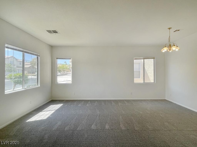carpeted spare room featuring an inviting chandelier, baseboards, and visible vents