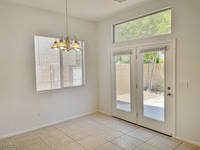doorway with light tile patterned flooring, baseboards, and a chandelier