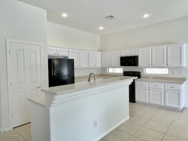 kitchen with visible vents, light tile patterned flooring, light countertops, white cabinetry, and black appliances