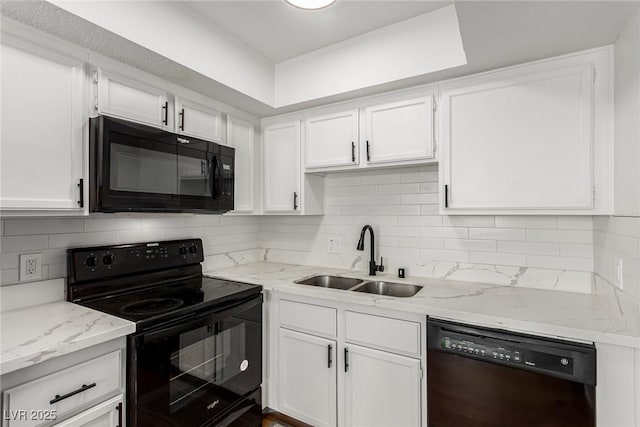 kitchen with a sink, decorative backsplash, white cabinets, and black appliances
