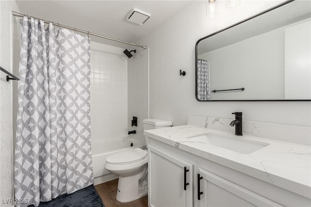 bathroom featuring visible vents, wood finished floors, vanity, toilet, and shower / bathtub combination with curtain