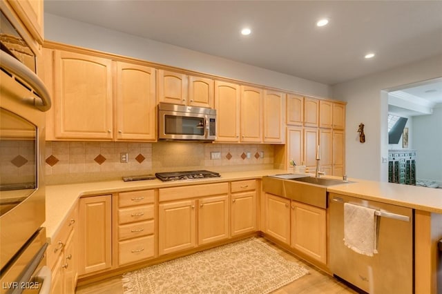 7349 Royal Melbourne Dr, Las Vegas, NV 89131 - kitchen with light countertops, light brown cabinets, stainless steel appliances, and a peninsula