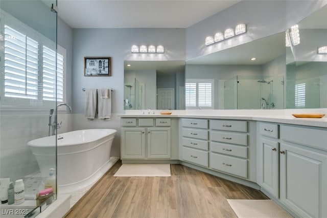 7349 Royal Melbourne Dr, Las Vegas, NV 89131 - bathroom with vanity, a freestanding tub, wood finished floors, and a stall shower