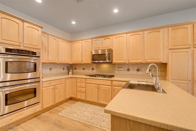 7349 Royal Melbourne Dr, Las Vegas, NV 89131 - kitchen with light wood-style floors, a sink, light brown cabinetry, and stainless steel appliances