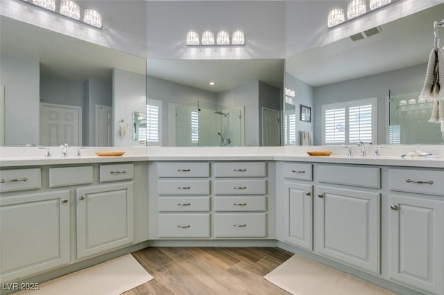7349 Royal Melbourne Dr, Las Vegas, NV 89131 - full bathroom with visible vents, a shower stall, wood finished floors, and vanity
