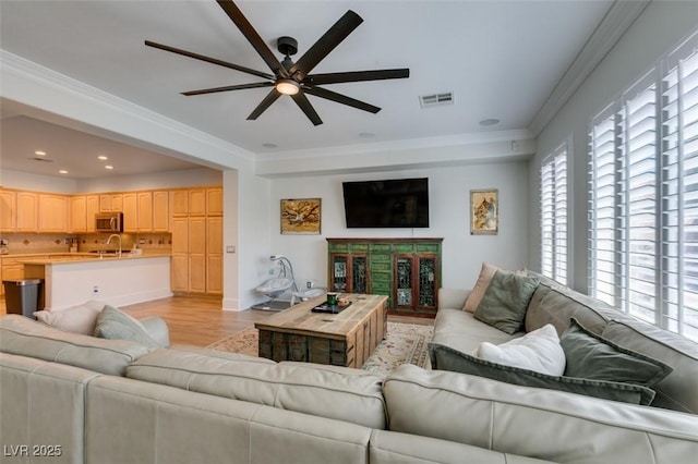 7349 Royal Melbourne Dr, Las Vegas, NV 89131 - living room featuring visible vents, a ceiling fan, light wood finished floors, and crown molding