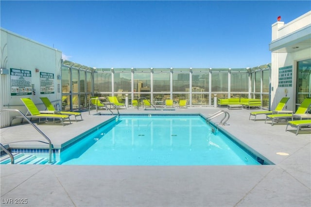 community pool with glass enclosure and a patio