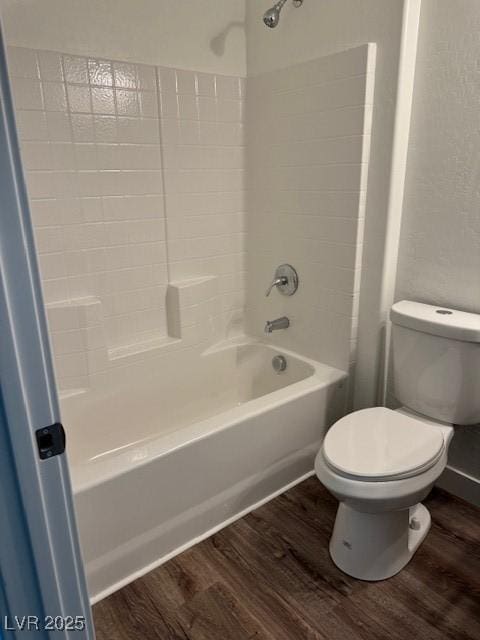 bathroom featuring shower / bathtub combination, wood finished floors, and toilet
