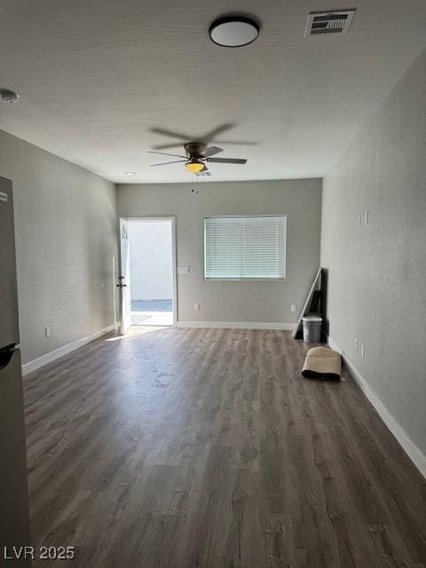 unfurnished living room featuring baseboards, a ceiling fan, wood finished floors, and visible vents