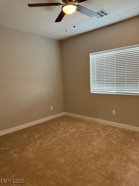 carpeted spare room with ceiling fan, visible vents, and baseboards