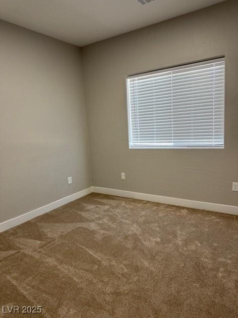 spare room featuring carpet floors, baseboards, and visible vents