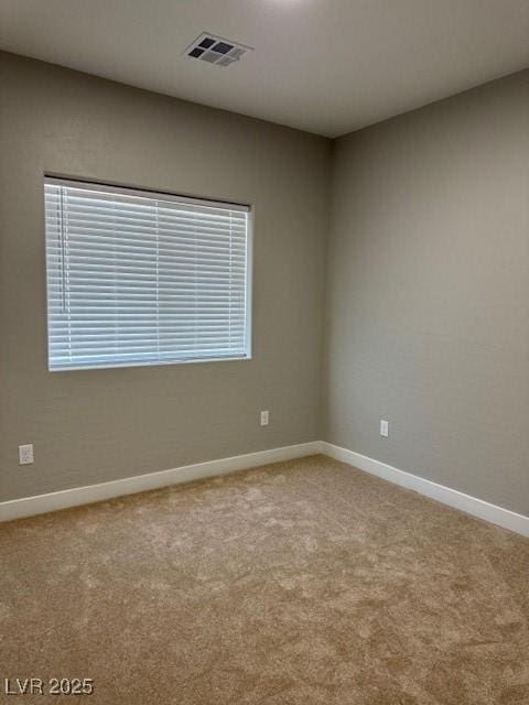 unfurnished room with visible vents, baseboards, and light colored carpet