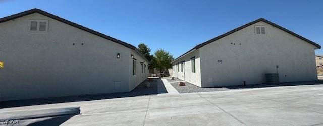 view of side of property featuring a patio area and stucco siding
