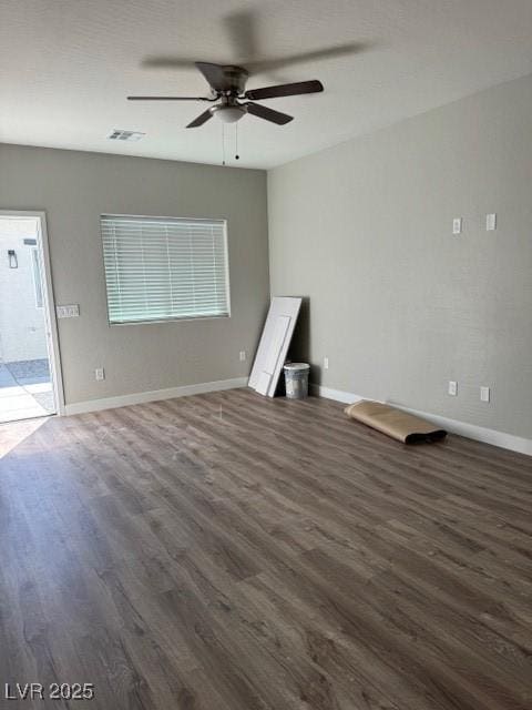 unfurnished room featuring baseboards, ceiling fan, visible vents, and wood finished floors