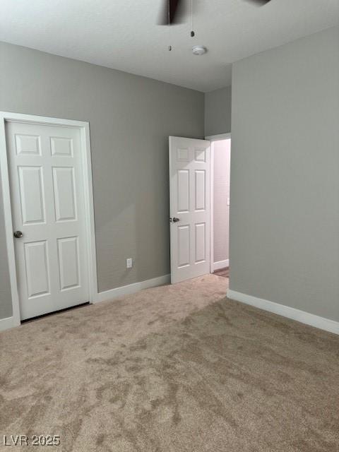 unfurnished bedroom with carpet floors, a ceiling fan, and baseboards