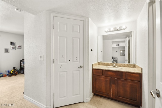 bathroom featuring vanity, baseboards, a textured ceiling, and visible vents