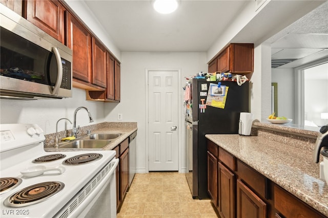 kitchen featuring a sink, appliances with stainless steel finishes, light tile patterned floors, and light stone countertops