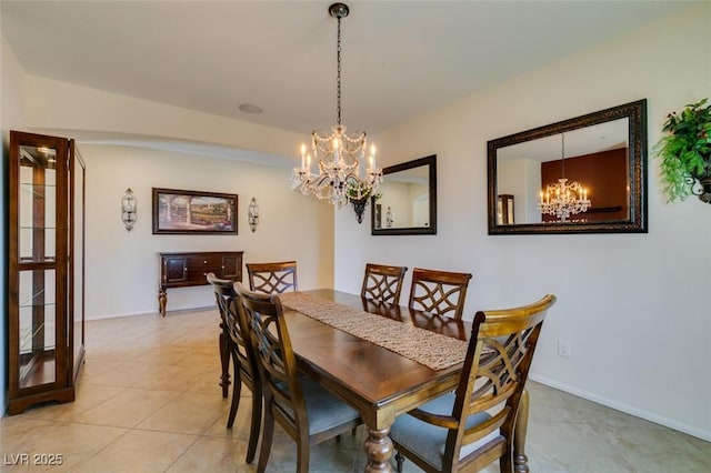 dining area with baseboards, light tile patterned floors, and a chandelier