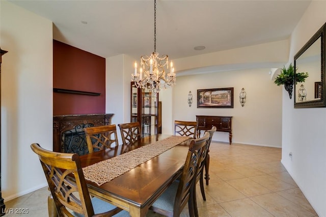dining area with light tile patterned floors, baseboards, and a notable chandelier