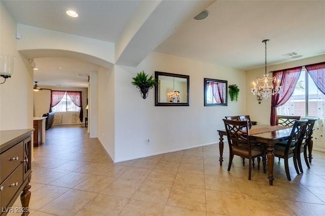 dining space featuring a notable chandelier, arched walkways, baseboards, light tile patterned floors, and visible vents