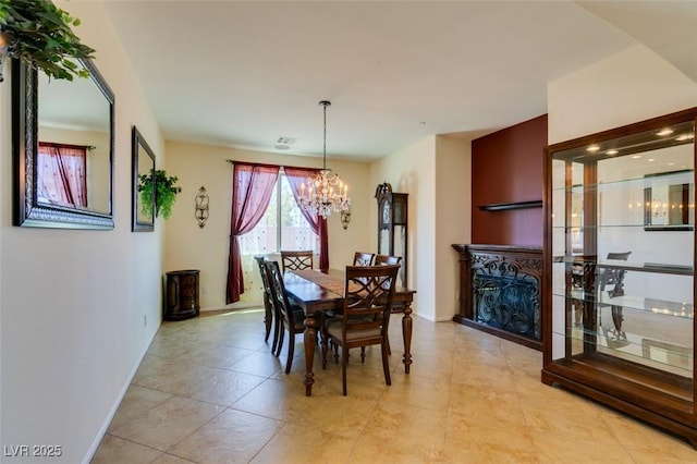 dining area with light tile patterned floors, baseboards, and a notable chandelier