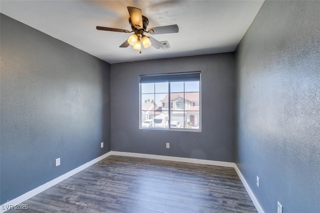 empty room with baseboards, ceiling fan, and wood finished floors