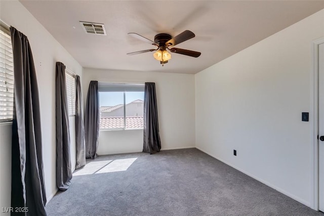 empty room with baseboards, carpet, a ceiling fan, and visible vents