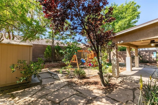 view of patio featuring ceiling fan, an outbuilding, and a fenced backyard
