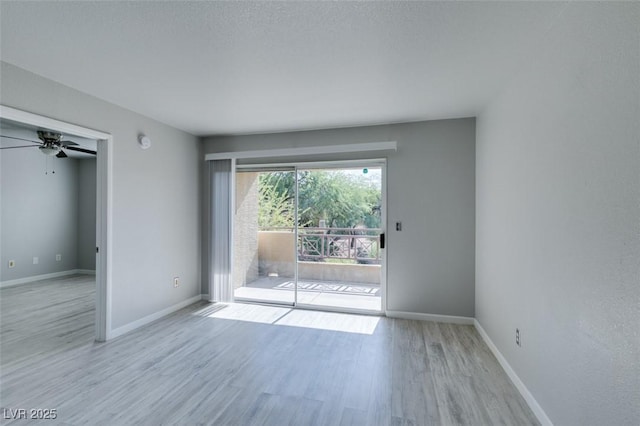 spare room with a ceiling fan, baseboards, and wood finished floors