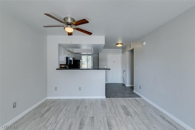 unfurnished living room featuring baseboards, ceiling fan, wood finished floors, and visible vents