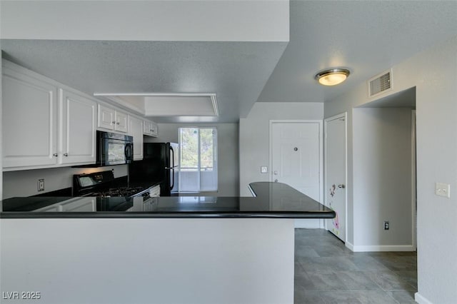 kitchen with visible vents, a peninsula, black appliances, and dark countertops